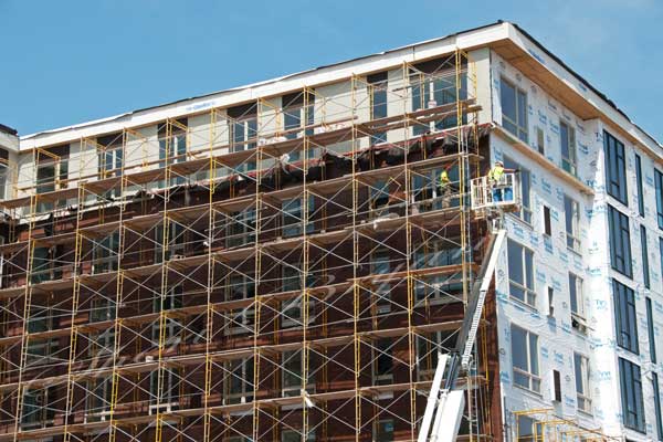 Apartment building under construction, college dorm under construction