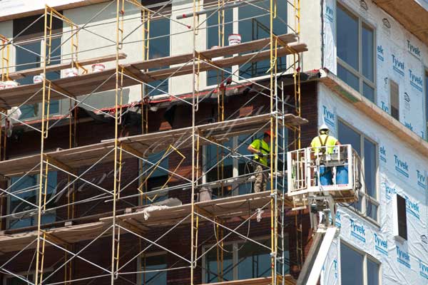 Apartment building under construction, college dorm under construction