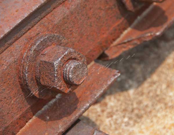 Large rusted nut and bolt on a rail track