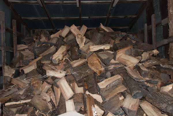 Split firewood stored in a metal tin shed  Wood