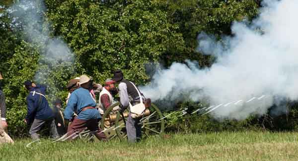 Civil War reenactment with reenactors firing a smoking canon on the Centralia Missouri Battlefield In Boone County.  Civil War era costumes and props